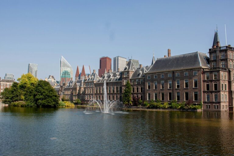 Binnenhof en skyline Den Haag Het Binnenhof in Den Haag met fontein in de Hofvijver en moderne skyline op de achtergrond